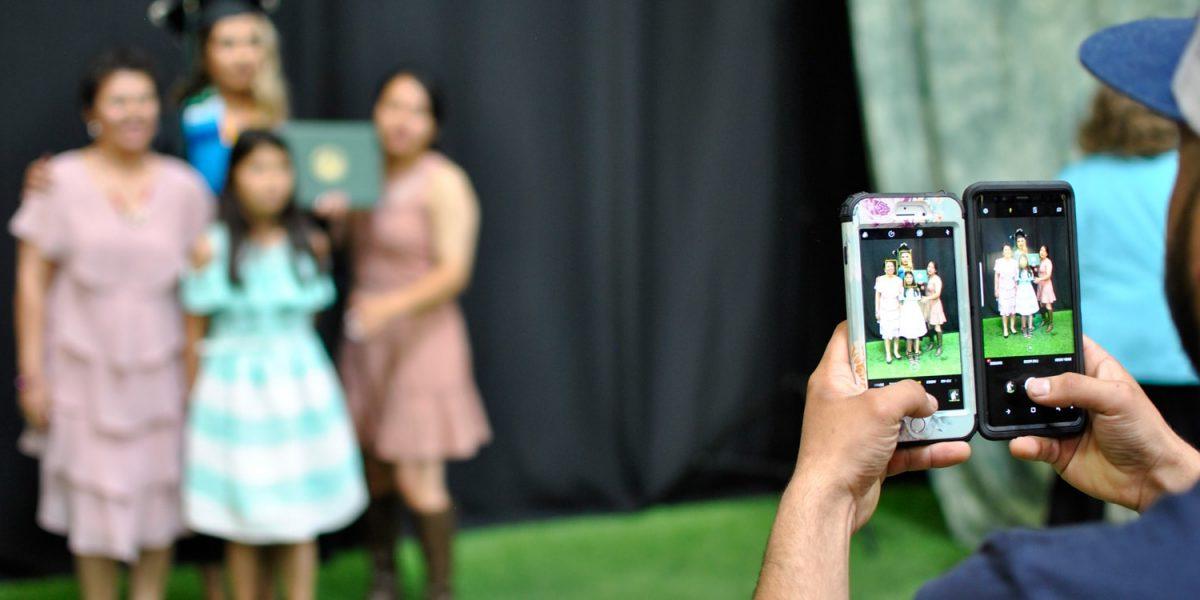 用两部手机给毕业生和她的家人拍照